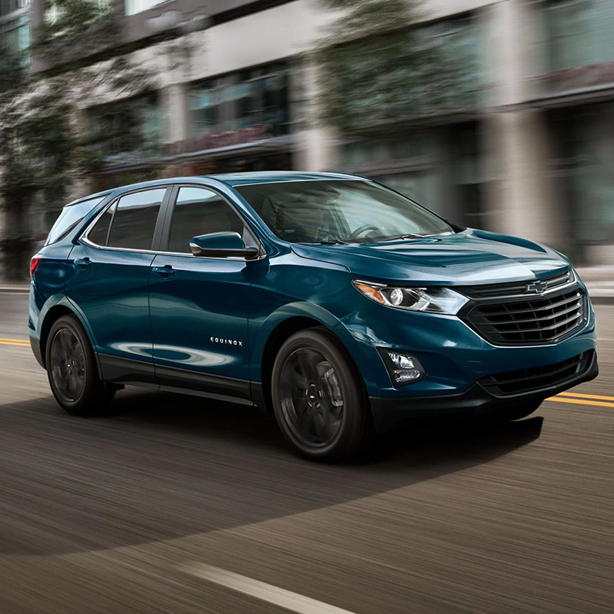 side profile of chevrolet equinox suv in blue color driving in front of a commercial building